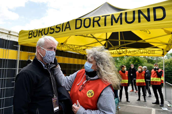 A member of the TV broadcast crew gets his temperature taken at Dortmund's stadium.